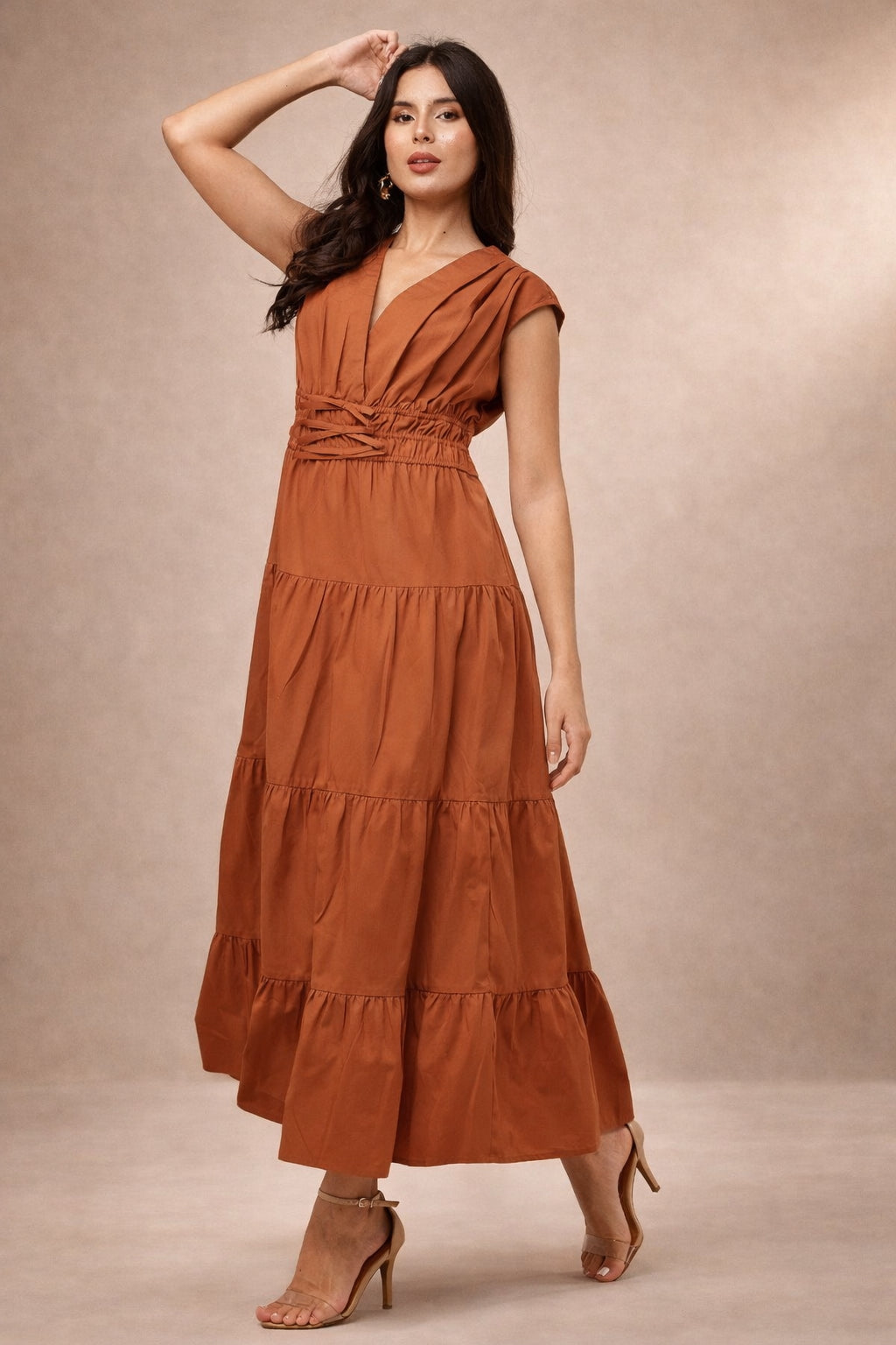 Woman wearing a rust-colored maxi dress against a beige background