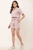 Woman wearing a pink and white checkered outfit with a white background