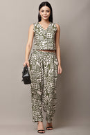 Woman wearing a Crop_Top and trouser outfit holding a black handbag against a plain background