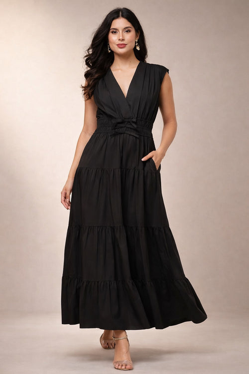 Woman wearing a black sleeveless maxi dress on a beige background