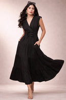 Woman wearing a black maxi dress with a plain background
