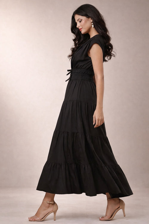 Woman wearing a black maxi dress against a neutral background