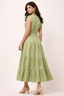 Woman wearing a green maxi dress on a white background