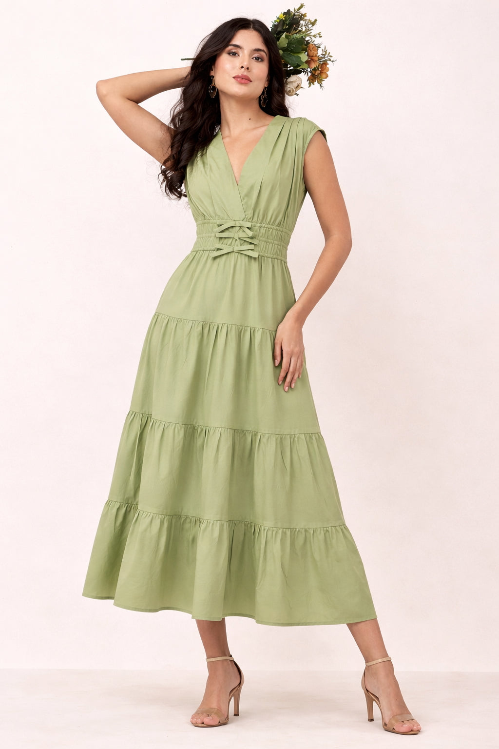 Woman wearing a green maxi dress with a white background