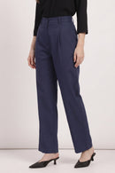 A model wearing navy blue high-waisted wide-leg trousers, paired with a black long-sleeve top and black pointed-toe mule heels, shown from the waist down against a plain light background.