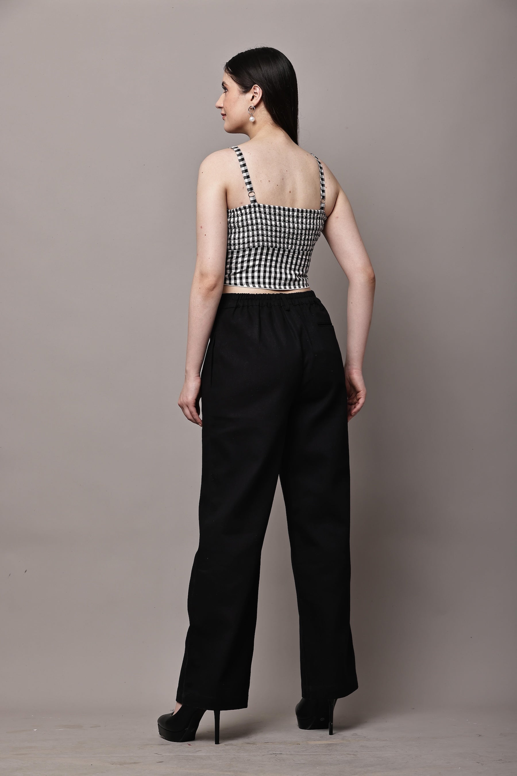 Back view of black and white gingham co-ord set for women with bustier crop top and high waist wide leg trousers
