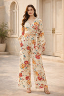 Woman wearing a floral outfit standing in front of a building entrance.