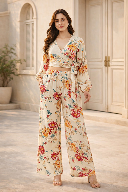 Woman wearing a floral outfit standing in front of a building entrance.